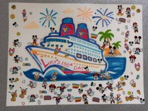 A colorful drawing of a cruise ship with Lucys 100th Day written on it, surrounded by Disney character stickers, palm trees, ocean waves, and fireworks in the sky.
